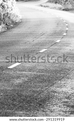 An image of a silent asphalt road after the rain. Image has a vintage effect.