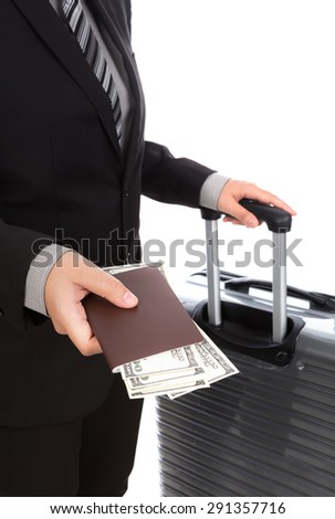 Business traveling pulling suitcase and holding passport