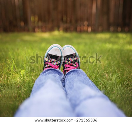 a wide angle photo of a pair of generic looking shoes like converse sneakers with pink shoe laces (SHALLOW DOF on the left shoe laces)