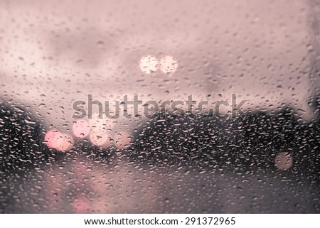 blurred image of traffic view through a car windscreen covered in rain,vintage filter