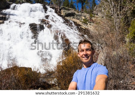 young man taking a self portrait or selfie with Eagle Falls in the background