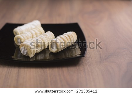 Delicious stack of several sweet roll cookies on wooden table