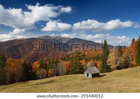 Autumn landscape on a sunny day. Wooden cottage in the mountains. Carpathians, Ukraine. Europe