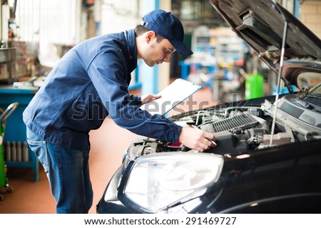 Portrait of a mechanic at work in his garage Royalty-Free Stock Photo #291469727