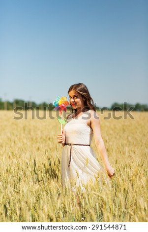 Happy girl with a colorful windmill in the field