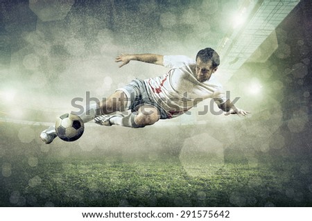 Soccer player with ball in action at stadium under rain.