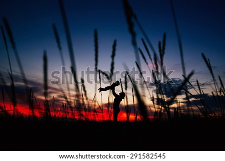 Silhouette of woman and a baby in the sunset