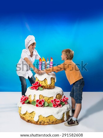 Cheerful confectioner and boy near a birthday cake