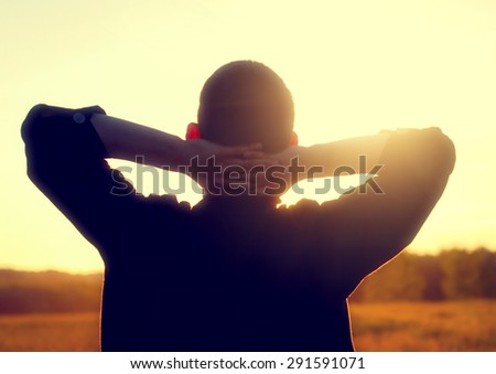 Toned Photo of Young Man Silhouette on Sunset Background