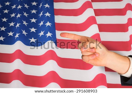 Hand pointing against rippled us flag