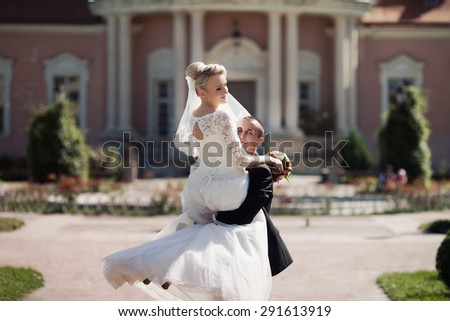 full of love stylish groom with  blonde bride on the background the old castle and amazing park