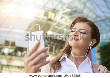Attractive young business woman with smart phone in the city