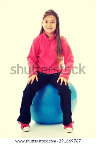 Little girl sitting on a big ball