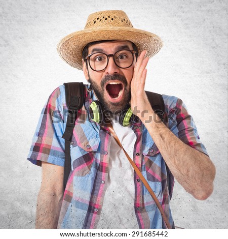 Tourist doing surprise gesture over grey background