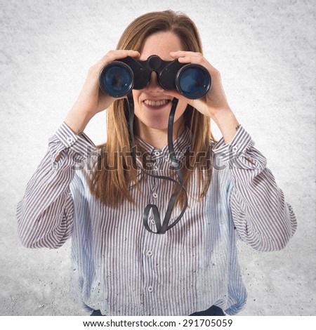 Girl with binoculars over textured background