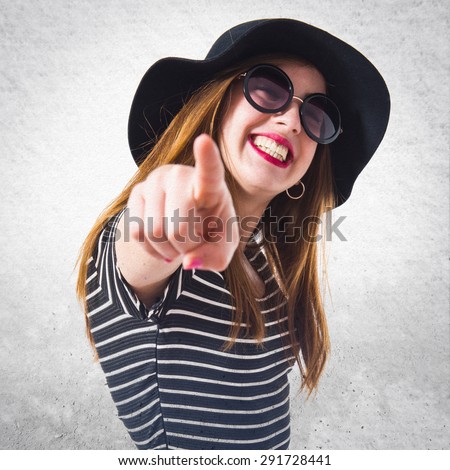 Girl pointing to the front over grey background