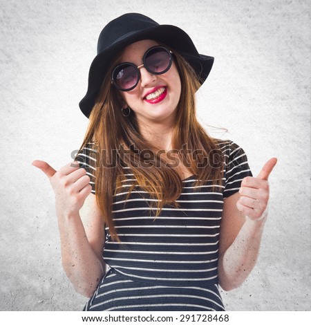 Girl with thumb up over grey background