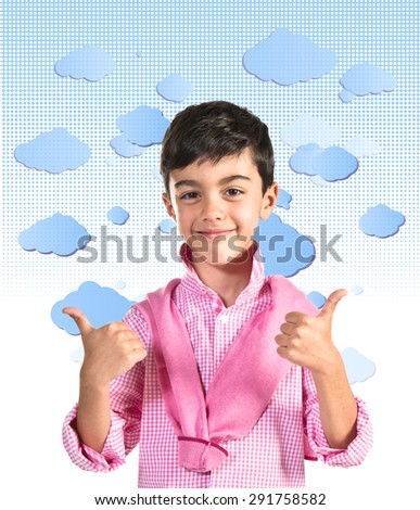 Boy with thumb up over clouds background