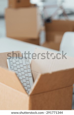 Open cardboard box and empty office on background, relocation concept, selective focus