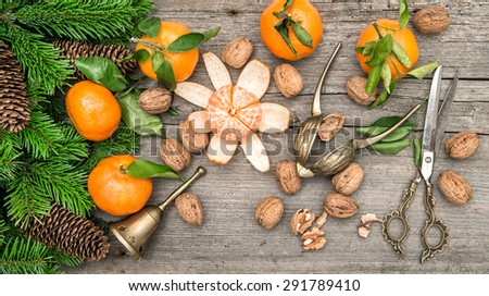 Christmas decoration with tangerine fruits and walnuts on wooden background
