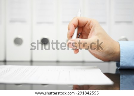 businessman is thinking about articles on contract before signing with binders in background Royalty-Free Stock Photo #291842555