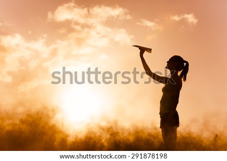 Young female getting ready to throw a paper airplane.  Royalty-Free Stock Photo #291878198