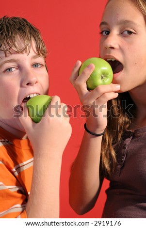 boy & girl eating an apple vertical