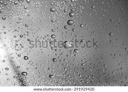 close-up raindrops on glass, black and white background