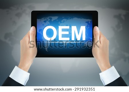 OEM (or Original Equipment Manufacturer) sign on tablet pc screen held by businessman hands