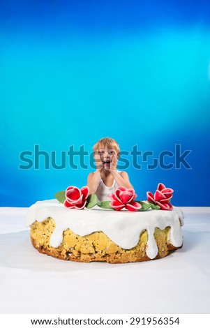 Cheerful boy sitting in the cake