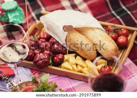 Beautiful bread with different food lies in the basket on the plaid