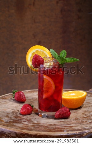 Wine of Sangrija in a transparent glass with a strawberry, an orange and mint

