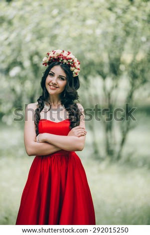 Beautiful girl with a wreath in red dress