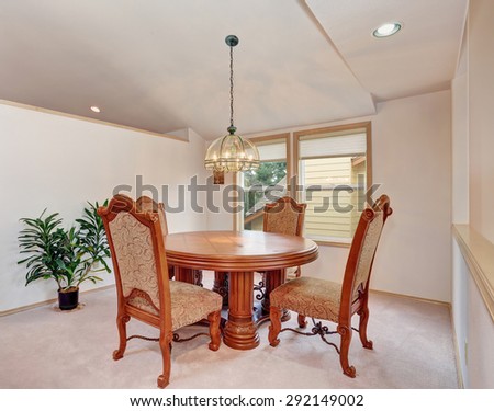 Simplistic dinning room with carpet, and nice table chairs set.