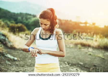Woman using activity tracker or heart rate monitor. Outdoor fitness concept. Toned image Royalty-Free Stock Photo #292193279