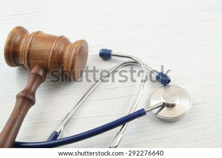 Judge's gavel and stethoscope on white wooden table Royalty-Free Stock Photo #292276640