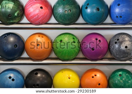 A rack of old worn bowling balls.