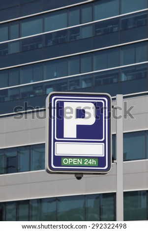 Parking signpost with open text and modern building background. Vertical