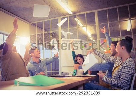 Group of business people celebrating by throwing their business papers in the air Royalty-Free Stock Photo #292331609