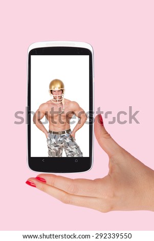 Online dating. Female hands holding smartphone with picture of handsome man isolated on pink background. Flirting and relationship in the information age.