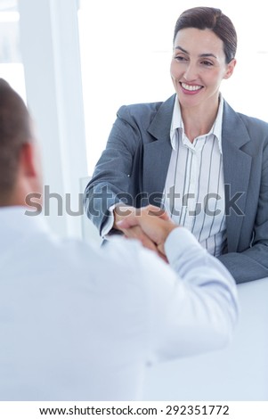 Businesswoman shaking hands with a businessman in an office