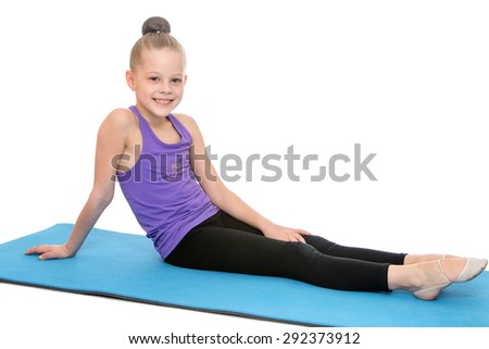 Slender beautiful young girl who is engaged in fitness sitting on the Mat in a t-shirt and sports tights - isolated on white background