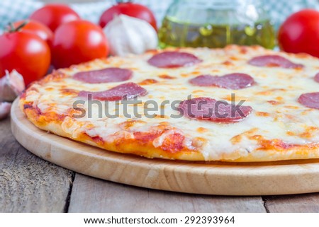 Homemade pepperoni pizza on a wooden board, ready to eat