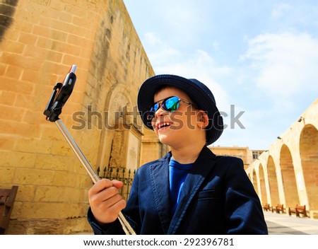 smart little boy taking selfie stick picture while travel in Europe, Malta