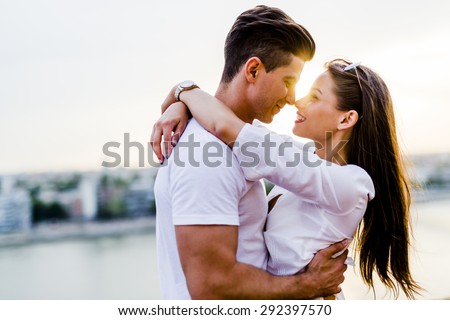 Young romantic couple hugging and about to kiss in beautiful sunset Royalty-Free Stock Photo #292397570