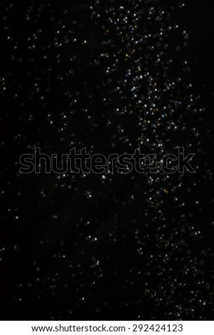 Bokeh lights on a black background with water intentionally blurred.