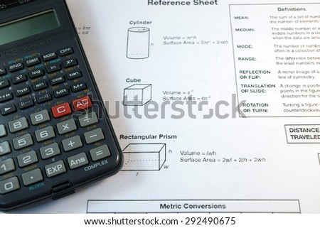 Eye Glasses, pen and pencil over the Formula with calculator 