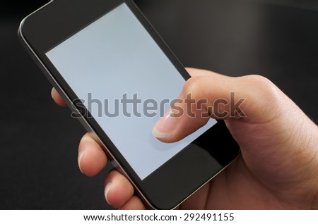 Woman operating a mobile phone with her right hand and thumb