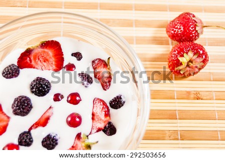 slices of ripe strawberries and blueberries in a glass bowl