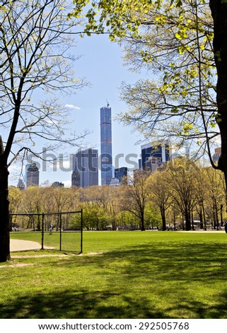 New York skyline seen from the baseball fields of Central Park through the trees